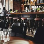 two person sitting on bar stool chair in front of bar front desk